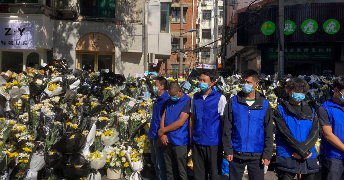 Chinese people collect and lay flowers despite tight security during the burial of former Premier Li Keqiang