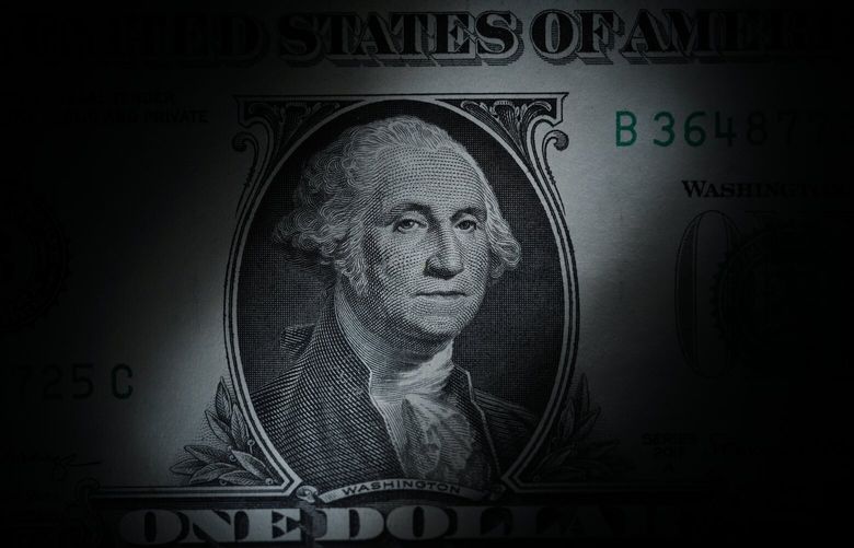 FILE – The likeness of George Washington is seen on a U.S. one dollar bill, March 13, 2023, in Marple Township, Pa. We often talk about 401(k)s and 403(b)s as if they’re the same, but they’re not. While both can help you save for retirement, 403(b)s have fewer consumer protections and can be a bad deal for the people — often teachers — they’re supposed to serve. If your employer offers a 403(b), research the plan thoroughly. (AP Photo/Matt Slocum, File) NYPS202 NYPS202