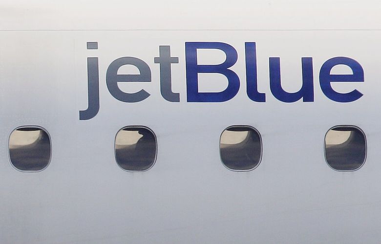 FILE – In this Jan. 20, 2011, file photo, a JetBlue logo is displayed on the side of a jet. (AP Photo/Stephan Savoia, File)