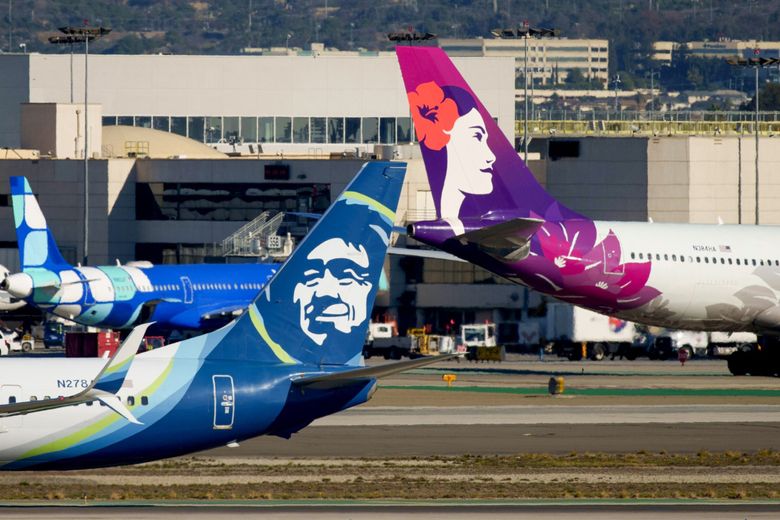 An Alaska Airlines airplane and a Hawaiian Airlines airplane at Los Angeles International Airport on Dec. 5 in Los Angeles. (Eric Thayer / Bloomberg)