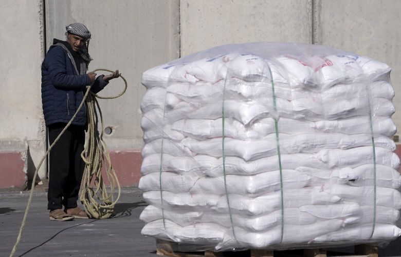 An Egyptian truck driver carrying humanitarian aid for the Gaza Strip unties his cargo after inspection at the Kerem Shalom Crossing in southern Israel, Friday, Dec. 22, 2023. (AP Photo/Maya Alleruzzo) XMA110 XMA110