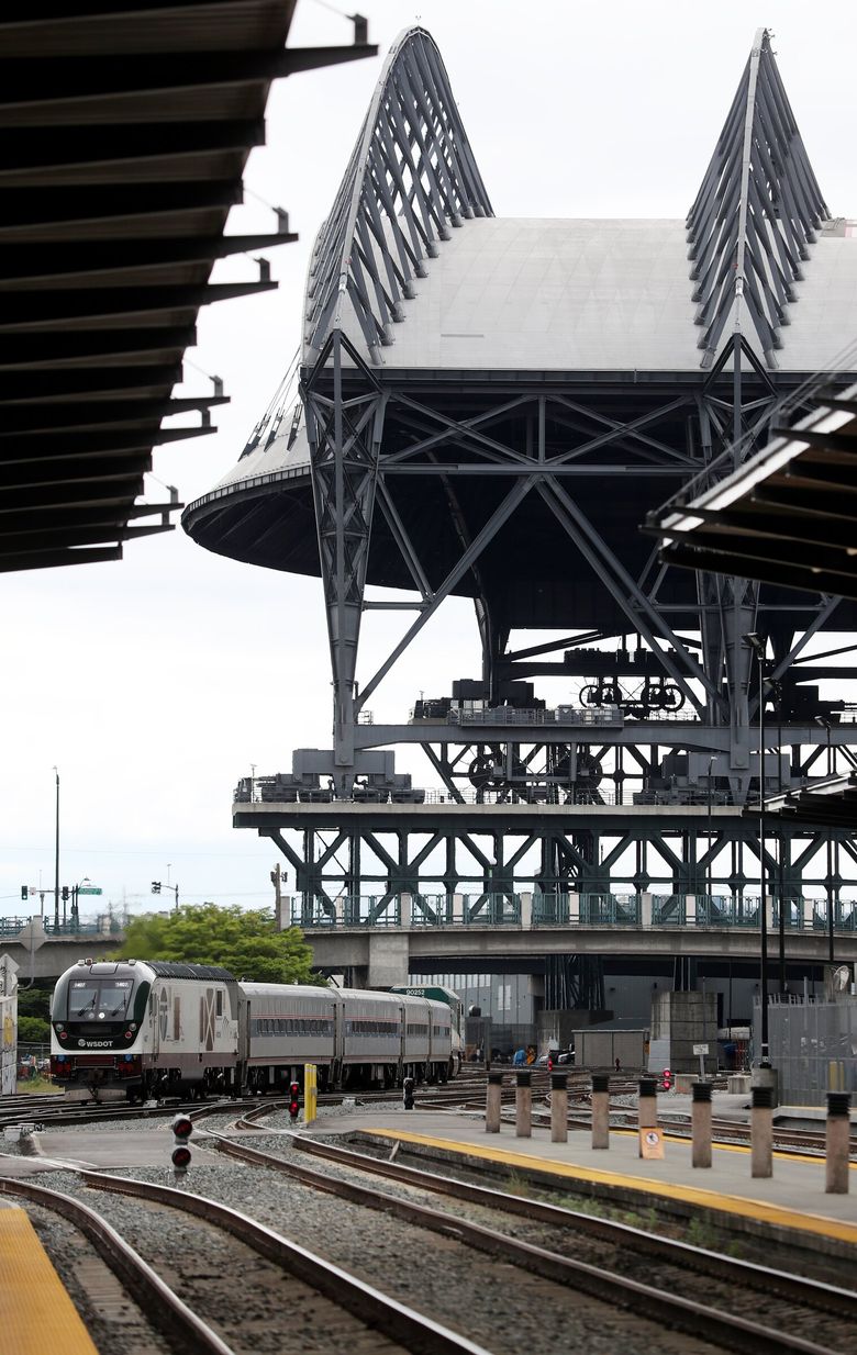 An Amtrak Cascades train from Portland passes T-Mobile Park as it arrives at King Street Station in Seattle. (Ken Lambert / The Seattle Times, 2021)