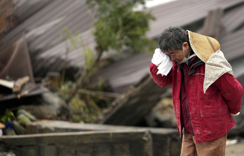 A man cries as a body of his family member was found from a collapsed house caused by powerful earthquake in Suzu, Ishikawa Prefecture Wednesday, Jan. 3, 2024. (AP Photo/Hiro Komae) XKS202 XKS202