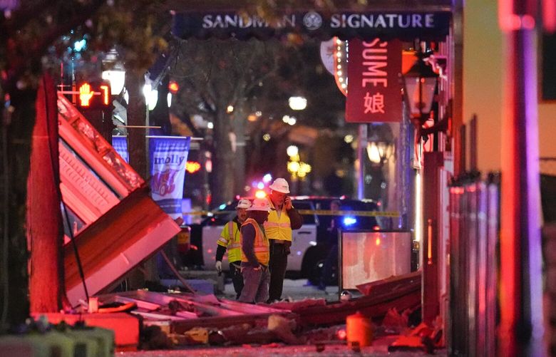 Workers survey damage near the Sandman Signature hotel following an explosion, Monday, Jan. 8, 2024, in Fort Worth, Texas. (AP Photo/Julio Cortez) TXJC107 TXJC107