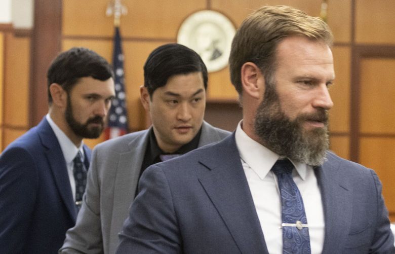 After the prosecution and defense have both rested their cases in the Manny Ellis trial being held in Pierce County Superior Court in Tacoma Wednesday, December 6, 2023, Tacoma officers being charged with the killing of Manny Ellis, from left, Christopher Burbank, Timothy Rankine and Matthew Collins, get up and head out of court. The jury has gone home and will be back in court Monday for closing arguments.  Tacoma Police Officers Christopher Burbank, Matthew Collins and Timothy Rankine stand trial for charges related to the March 2020 killing of Manny Ellis. (Ellen M. Banner / Pool / The Seattle Times)