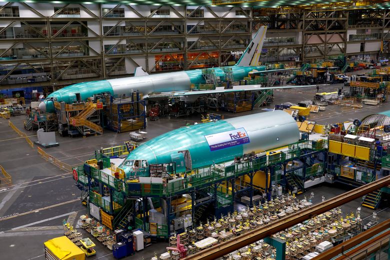 777 freighters are seen in various stages of assembly at Boeing’s Everett assembly plant in 2022. Boeing&#8217;s historical dominance in the widebody cargo jet market is threatened by a new global aviation carbon emissions standard that could shutter the 777 freighter line at the end of 2027. (Jennifer Buchanan / The Seattle Times)