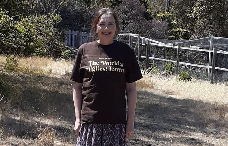 Kathleen Murray, who lives in Tasmania, stands on her lawn, which won a “World’s Ugliest Lawn” contest this month. MUST CREDIT: Kathleen Murray.