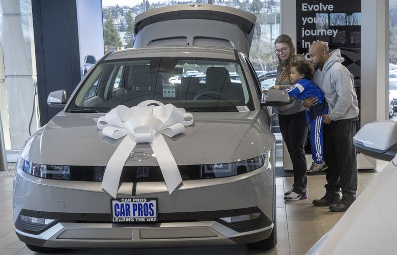 Ashley Webb (l) checks out a Hyundai Ioniq 5 EV  with her husband Angelo Harris and son Lorenzo, 4, at  Car Pros Kia & Hyundai in Renton Tuesday, January 23, 2024.  The family was there to purchase two cars. At right is a Hyundai Kona EV.

 Car shopping is shifting back in favor of the buyer as the lots are full, buyers have more choices and dealerships will be under a lot more pressure this year to clear their lots in the wake of more competition.

 In  2024, hybrids are super popular, but EVs are a bit out of favor compared to last year, likely due to the recent drop in gas prices and fewer incentives.   226004 (Ellen M. Banner / The Seattle Times)