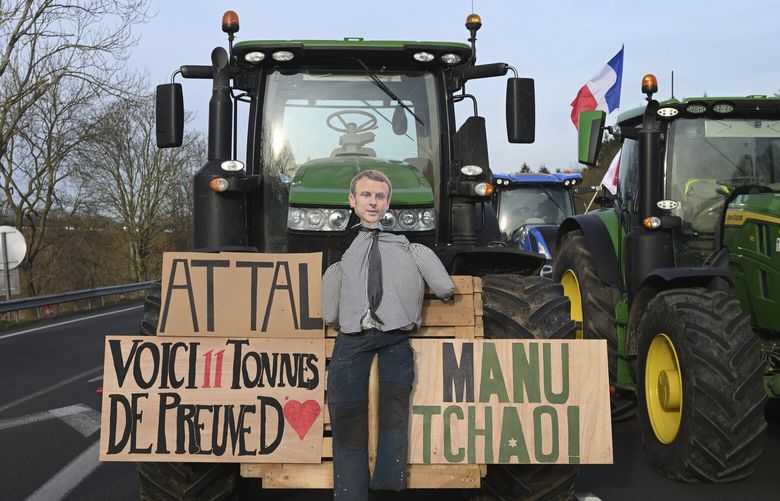 An effigy of French President Emmanuel Macron is seen on a tractor as farmers demonstrate on a highway near Paris’s main airport, Monday, Jan. 29, 2024 near Roissy-en-France, north of Paris. Protesting farmers vowed to encircle Paris with tractor barricades and drive-slows on Monday, aiming to lay siege to France’s seat of power in a battle with the government over the future of their industry, which has been shaken by repercussions of the Ukraine war. (AP Photo/Matthieu Mirville) PAR133 PAR133