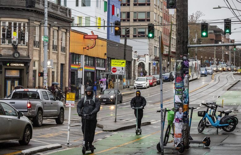 Adults on scooters during the afternoon commute, Wednesday, Jan. 24, 2024 at Broadway and Pike, which is within a Seattle census tract estimated to have no children, according to census data.  226013