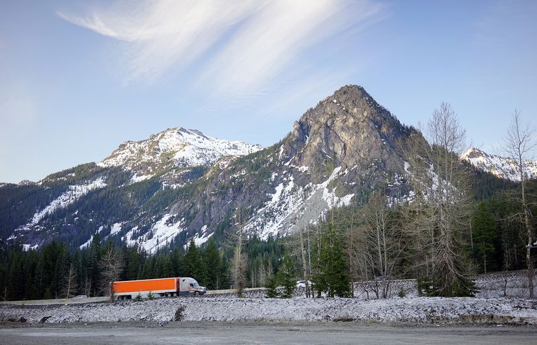 A truck drives up I90 near Snoqualmie Pass on a clear winter day