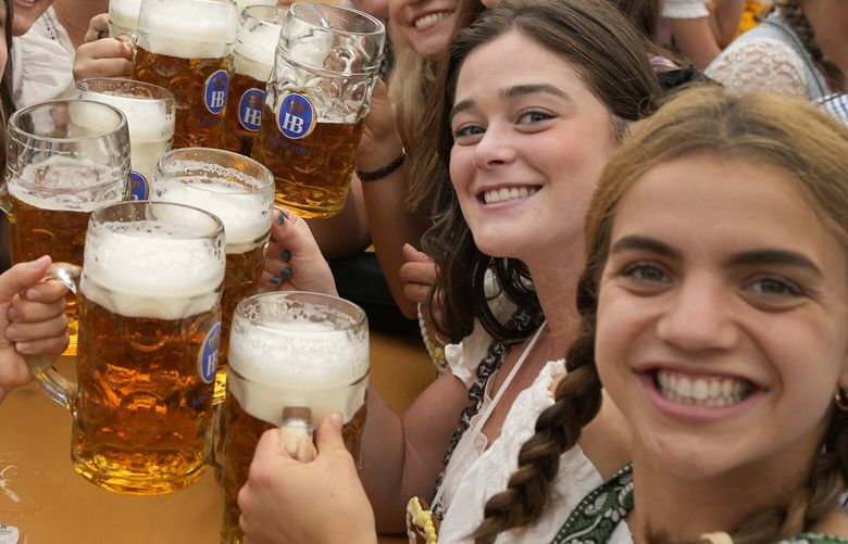 FILE – Women with glasses of beer pose for a photo on day one of the 188th ‘Oktoberfest’ beer festival in Munich, Germany, Saturday, Sept. 16, 2023. German beer sales dropped 4.5% last year, resuming a long-term downward trend after an uppick in 2022 following the end of COVID-19 restrictions, official figures showed Thursday. (AP Photo/Matthias Schrader, File) DSOB101 DSOB101