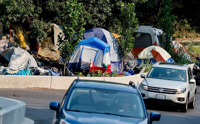 During the summer of 2023, dozens of tents are squeezed into a triangular median in North Burien formed by the intersection of Ambaum Blvd. SW, 12th Ave SW and SW 120th St. in Burien. (Jennifer Buchanan / The Seattle Times)
