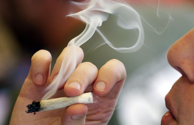 FILE – In this April 20, 2016, file photo, a man smokes a marijuana joint at a party celebrating weed in Seattle. Legalizing recreational marijuana for U.S. adults may have led to a slight decline in teen use. Thatâ€™s according to research published Monday, July 8, 2019, in JAMA Pediatrics.  (AP Photo/Elaine Thompson, File)