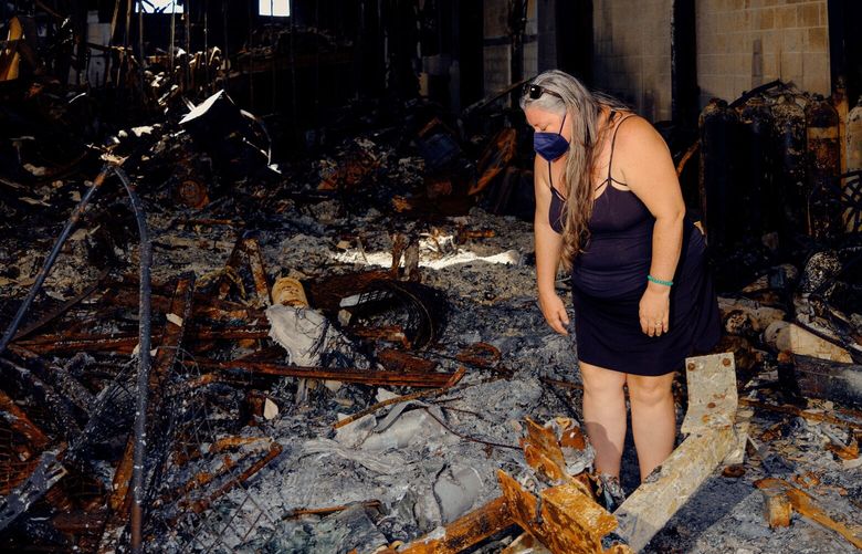 Victoria Martocci looks over the charred remains of her scuba diving business, burned in last year’s wildfire on Maui, in Lahaina, Hawaii on Jan.15, 2024. Six months after the Maui wildfire, hundreds of businesses remain closed, and questions linger about how much a local economy should rely on tourism. (Brendan George Ko/The New York Times)