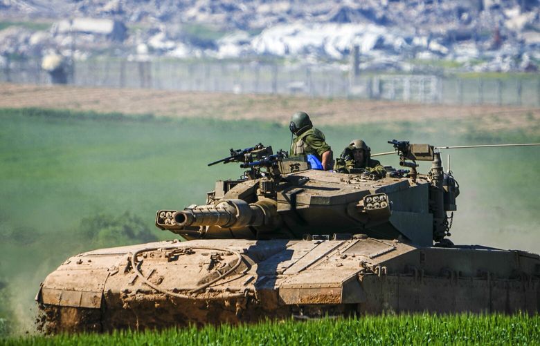 Israeli soldiers drive a tank on the border with the Gaza Strip, as seen in southern Israel, Sunday, Feb. 11, 2024. The army is battling Palestinian militants across Gaza in the war ignited by Hamas’ Oct. 7 attack into Israel. (AP Photo/Ariel Schalit) ASC104 ASC104