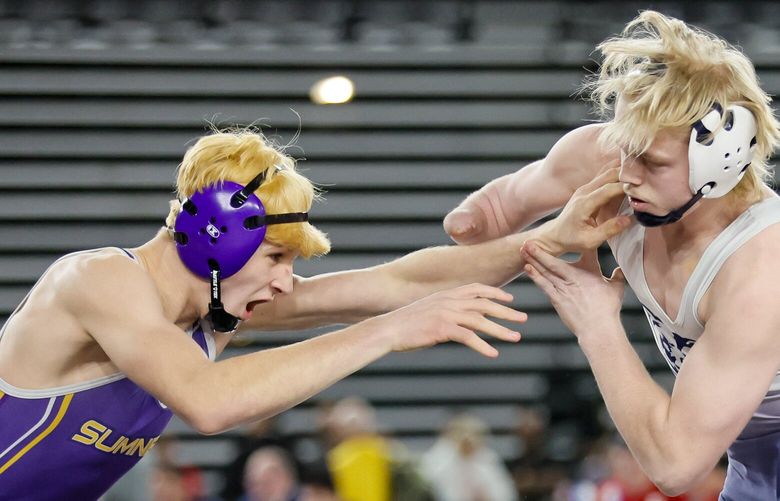 Cody Miller from Sumner, left, lunges for the face of Landon Porter from Olympia during the 4A 157 pound final Saturday, Feb. 17, 2024 in Tacoma. 226125