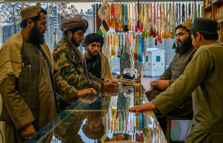 Former Taliban fighters look at perfume in a shop in central Kabul. MUST CREDIT: Elise Blanchard for The Washington Post