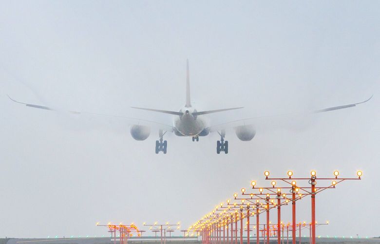 A plane comes in for a landing in heavy fog at Sea-Tac International Airport Thursday, December 26, 2019.  Nearly  158,000 passengers were expected to arrive or depart or catch connecting flights at the airport and many flights were delayed due to stormy weather across the U. S.  There were long lines at the airport, one of the busier travel days of the year.   212518 212518