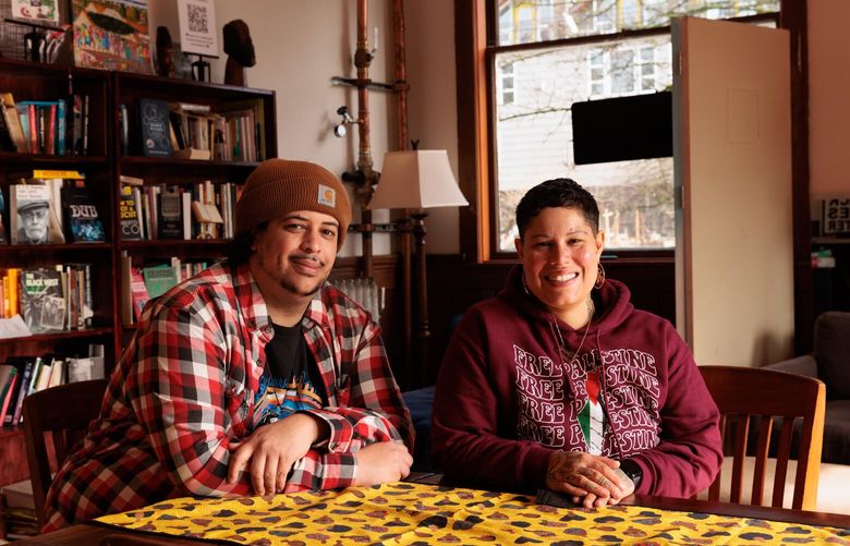 Creative Cafe director Daniel Bash, left, and Creative Justice executive director Nikkita Oliver are photographed in Creative Cafe’s library, a second living room for community members, inside Washington Hall in Seattle’s Central District. (Erika Schultz / The Seattle Times)