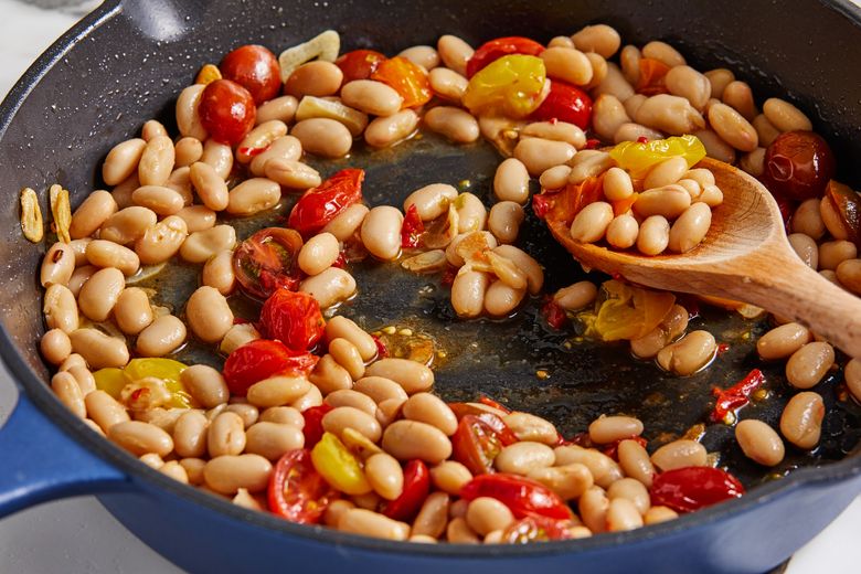 A satisfying skillet dinner of hearty beans and succulent shrimp, flecked with bites of tomato and ribbons of spinach. (Tom McCorkle for The Washington Post)