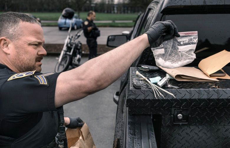 Un agente de policía confisca casi dos onzas de metanfetamina en un parque en Salem, Oregón, el 20 de febrero de 2024. Oregón eliminó las sanciones penales por posesión de drogas callejeras en 2020, pero después de que las muertes por sobredosis se dispararan, los legisladores estatales votaron para restablecer algunas restricciones. (Jordan Gale/The New York Times) XNYT0699 XNYT0699