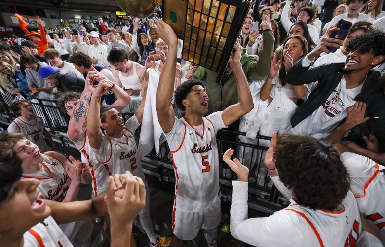 Eastside Catholic’s Jacob Cofie hoists the trophy Saturday evening after the 3A State Basketball Championships finals at the Tacoma Dome in Tacoma, Washington, on March 2, 2024. Eastside Catholic won 65-57. 226261