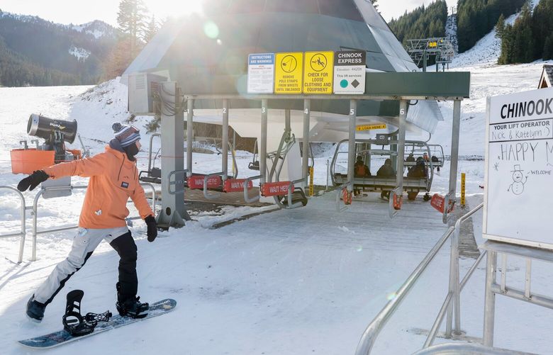 A snowboarders skates into the Chinook Express chairlift at Crystal Mountain.  222234