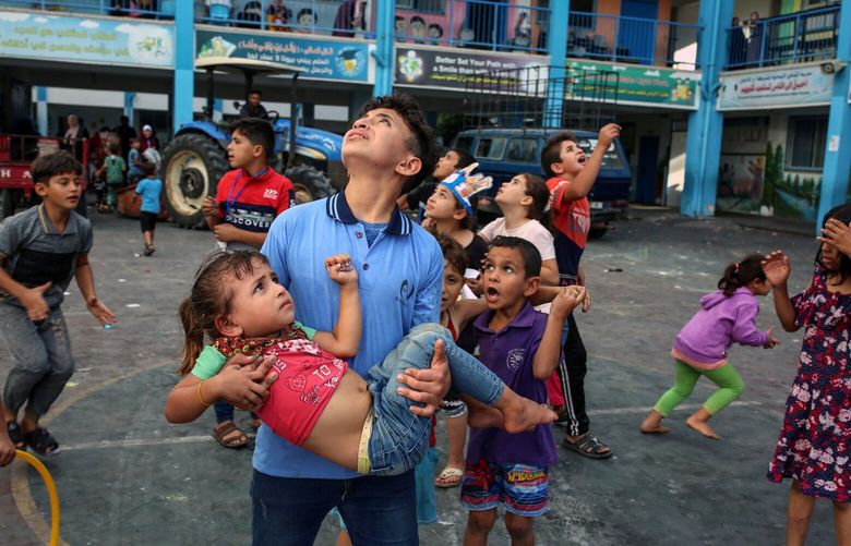 FILE – Palesinian children seeking shelter at a school in Gaza City look to the sky as Israeli jets fly overhead on Oct. 7, 2023, in one of Israel’s first responses to the Hamas terrorist attack. This photograph by Samar Abu Elouf was among The New York Times’s portfolio of images that won the Polk award for photojournalism on Monday, Feb. 19, 2024.  (Samar Abu Elouf/The New York Times) XNYT0683 XNYT0683