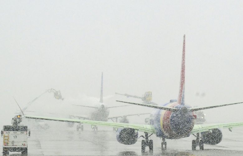 Crews work to deice airplanes at Denver International Airport during a major snowstorm that led to the cancellation of over 800 flights in Denver, Colorado on Thursday, March 14, 2024. (RJ Sangosti/The Denver Post via AP) CODEN101 CODEN101