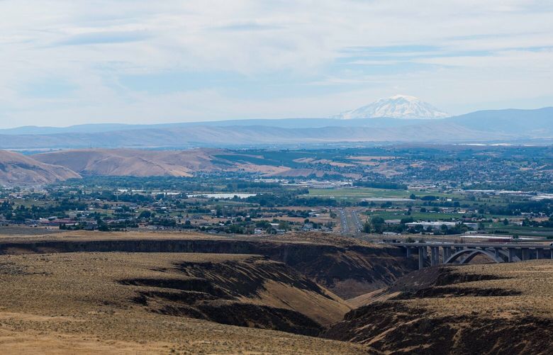 Mount Adams looms out over the Yakima valley as I-82 whisks traffic north and south. The Yakima Training Center can be seen at the left as shot Thursday, July 21, 2022, in Yakima, Wash. 220920