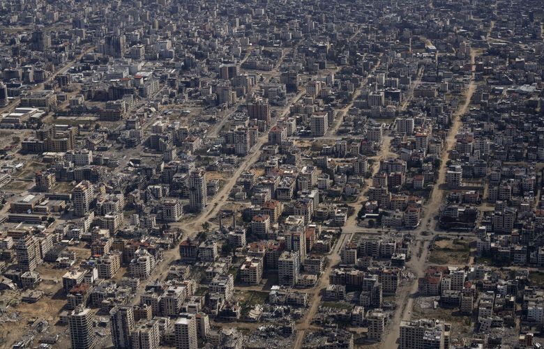Destroyed buildings are seen through the window of an airplane from the U.S. Air Force overflying the Gaza Strip, Thursday, March 14, 2024. (AP Photo/Leo Correa) XLC109 XLC109