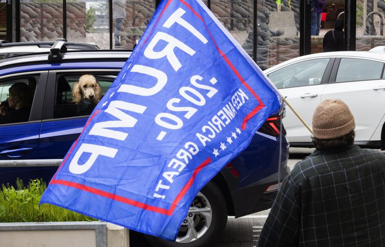 A solitary Trump supporter with a flag is on hand for International Workers Day for immigrant and workers rights, Monday, May 1, 2023 in downtown Seattle. 223702
