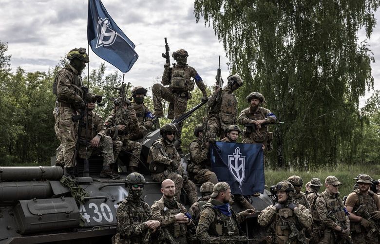 Members of the Free Russia Legion and the Russian Volunteer Corps pose for reporters during a media event in the Sumy region of Ukraine, May 24, 2023. The soldiers are Russians who have turned against the government of their country’s president, Vladimir Putin, and are now fighting for the Ukrainian side by making incursions back into Russia. (Finbarr O’Reilly/The New York Times) XNYT0307 XNYT0307