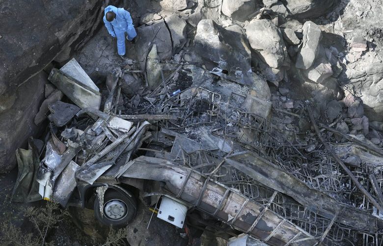 The wreckage of a bus lays in a ravine a day after it plunged off a bridge on the Mmamatlakala mountain pass between Mokopane and Marken, around 300km (190 miles) north of Johannesburg, South Africa, Friday, March 29, 2024. The bus carrying worshippers on a long-distance trip from Botswana to an Easter weekend church gathering in South Africa plunged off a bridge on a mountain pass Thursday and burst into flames as it hit the rocky ground below, killing at least 45 people, authorities said. The only survivor was an 8-year-old child who was receiving medical attention for serious injuries. (AP Photo/Themba Hadebe) XTH103 XTH103