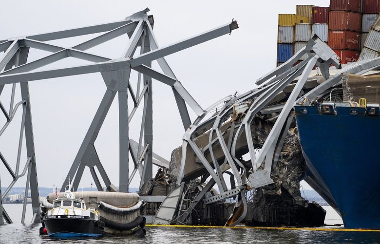 A small boat works alongside the container ship Dali and the collapsed Francis Scott Key Bridge in Sparrows Point, Md., on March 30, 2024. Twenty-two seafarers from India find themselves not only trapped in the ship that struck the Francis Scott Key Bridge, but also in an unexpected spotlight. (Pete Kiehart/The New York Times) XNYT0115 XNYT0115