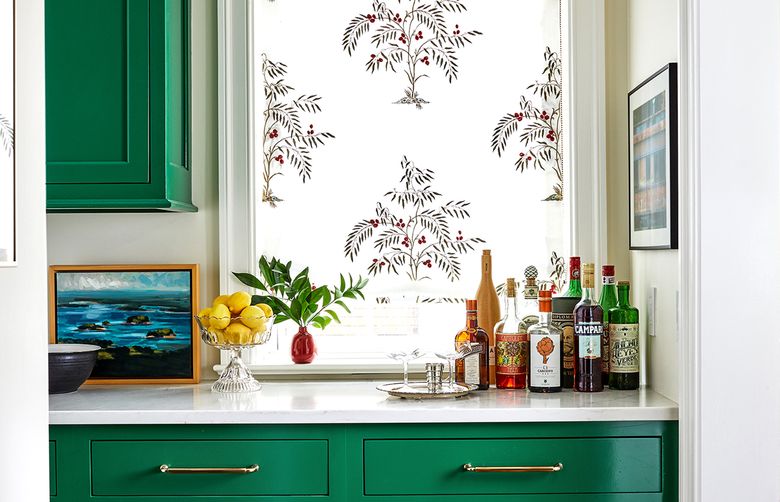 A tiny red vase accents the green butler’s pantry in this space designed by Annie Elliott. (Courtesy of Stacy Zarin Goldberg)