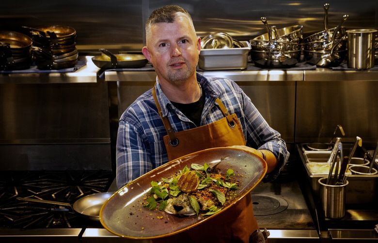 Eric Donnelly, owner and Executive Chef of RockCreek Seafood and Spirits, holds the Grilled Grecian Branzino with Italian everything spice, pickled chilis, grilled lemon and herbes at the restaurant’s new Kirkland location, Thursday, March 28, 2024.