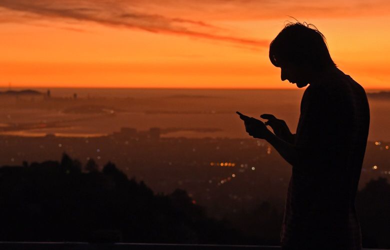Kris Bel, of Concord, checks his smartphone from Grizzly Peak Blvd. in Oakland, Calif., on Saturday, Oct. 26, 2019. A 2024 bill could make California the first state to give workers the right to ignore calls, texts, emails, and other communications from work outside their normal work hours. (Jose Carlos Fajardo/Bay Area News Group) 107372097P