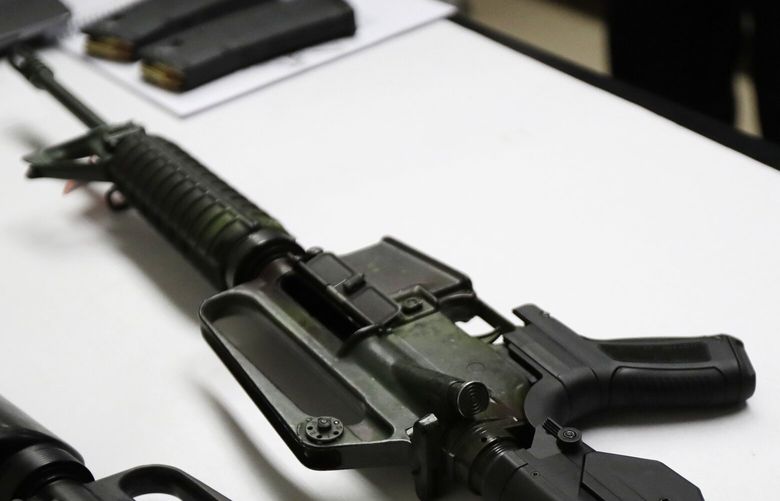 In this Jan. 11, 2018 photo, a semi-automatic rifle at right that has been fitted with a so-called bump stock device to make it fire faster sits on a table at the Washington State Patrol crime laboratory in Seattle.  (AP Photo/Ted S. Warren) WATW405