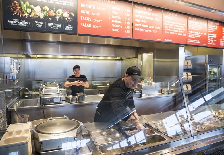 A Chipotle Mexican Grill employee prepares food in Seattle in 2015. (Stephen Brashear / AP)