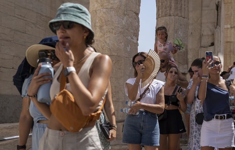 FILE – Tourists visit the ancient Acropolis hill during a heat wave in Athens, Greece, on July 21, 2023. Climate change is making heat waves crawl slower across the globe and last longer with higher temperatures over larger areas, a new study finds. (AP Photo/Petros Giannakouris, File) CLI501 CLI501