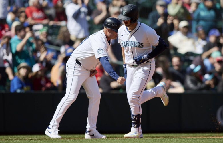 Seattle Mariners designated hitter Mitch Garver is congratulated by third base coach Manny Acta as he rounds the bases after hitting a solo home run off a pitch fromCincinnati Reds pitcher Andrew Abbott during the sixth inning of a baseball game, Wednesday, April 17, 2024, in Seattle. (AP Photo/John Froschauer) WAJF109 WAJF109