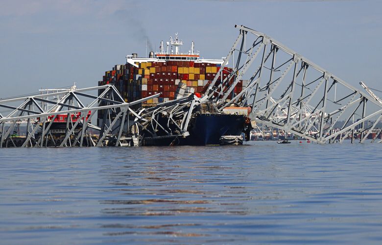 The collapsed Francis Scott Key Bridge lays on top of the container ship Dali, Monday, April 15, 2024, in Baltimore. The FBI confirmed that agents were aboard the Dali conducting court-authorized law enforcement activity. (AP Photo/Julia Nikhinson) MDJN106 MDJN106