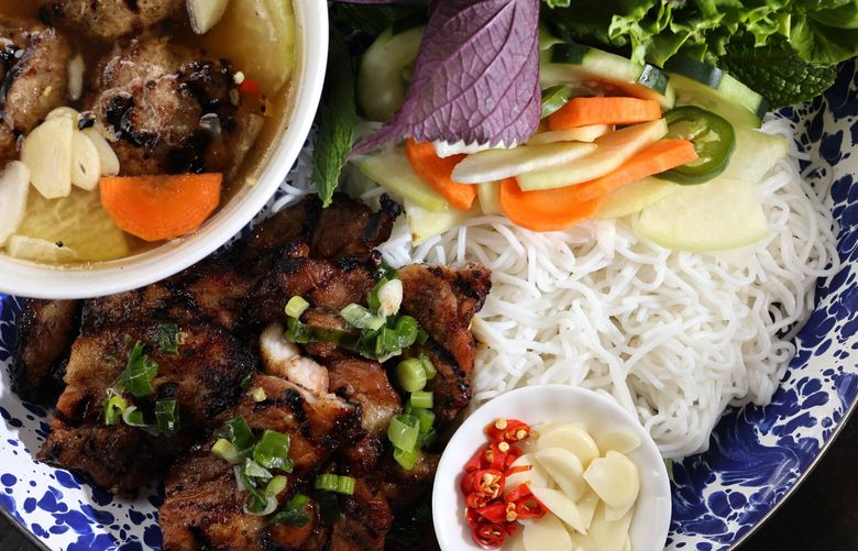 A meal from Ba Bar: Bun Cha Hanoi with pork sausage patties, marinated pork belly, rice noodle, lettuce, herbs, peanuts, shallot, pickled daikon & carrot, cucumber and bean sprouts in Seattle on Tuesday, April 9, 2024.