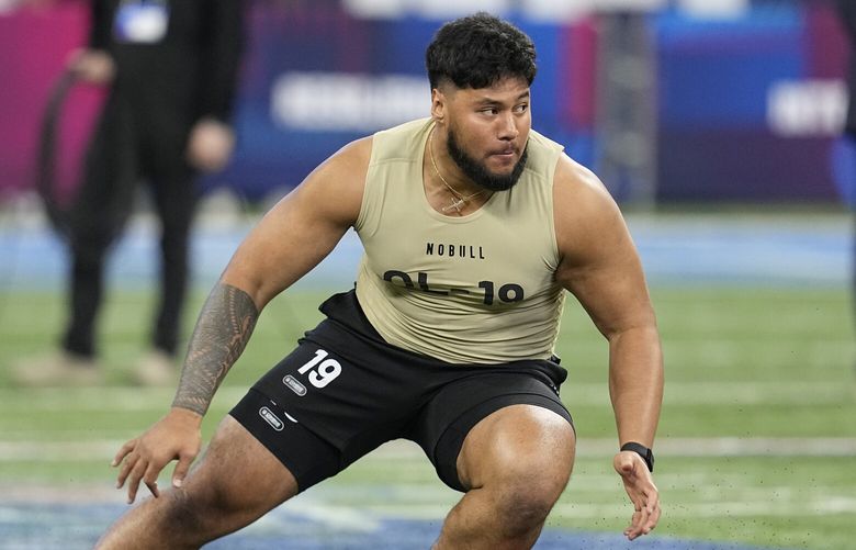 Washington offensive lineman Troy Fautanu runs a drill at the NFL football scouting combine, Sunday, March 3, 2024, in Indianapolis. (AP Photo/Darron Cummings)