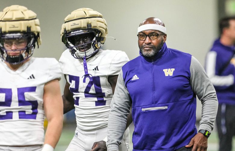 Running backs coach Scottie Graham works with his unit including #24 Adam Mohammed Wednesday.  The University of Washington Huskies practiced Wednesday, April 24, at Dempsey Indoor. 226735