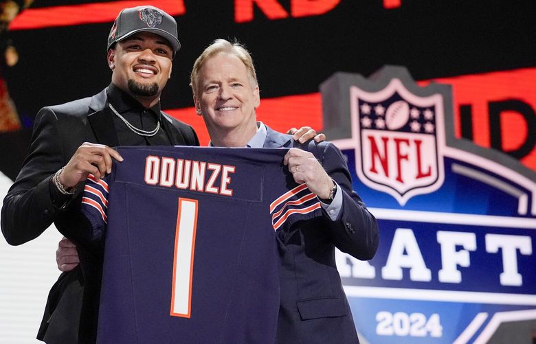 Washington wide receiver Rome Odunze, left, poses with NFL Commissioner Roger Goodell after being chosen by the Chicago Bears with the ninth overall pick during the first round of the NFL football draft, Thursday, April 25, 2024, in Detroit. (AP Photo/Jeff Roberson) MIJL229