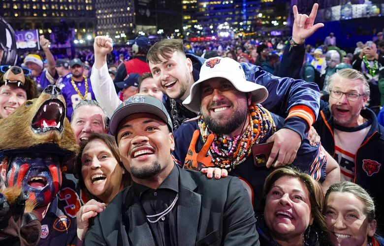 Washington wide receiver Rome Odunze celebrates with fans after being chosen by the Chicago Bears with the ninth overall pick during the first round of the NFL football draft, Thursday, April 25, 2024, in Detroit. (AP Photo/Paul Sancya) MIJL233