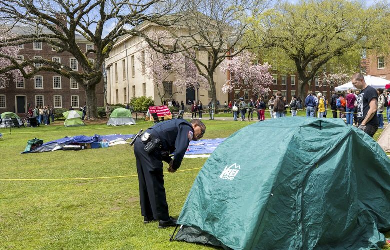 Campus police check student IDs at a pro-Palestinian encampment at Brown University in Providence, R.I., on Wednesday, April 24, 2024. There were nearly two dozen new arrests, mostly in Texas, as universities moved to prevent pro-Palestinian encampments from taking hold as they have at Columbia University. (Philip Keith/The New York Times) XNYT0961 XNYT0961